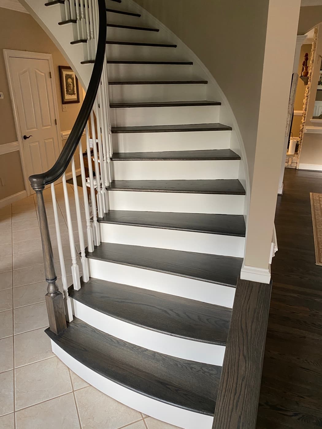 Finished curved grand staircase with Bona Driftwood stained red oak treads viewed from above at Sunset Lakes Fuquay-Varina NC
