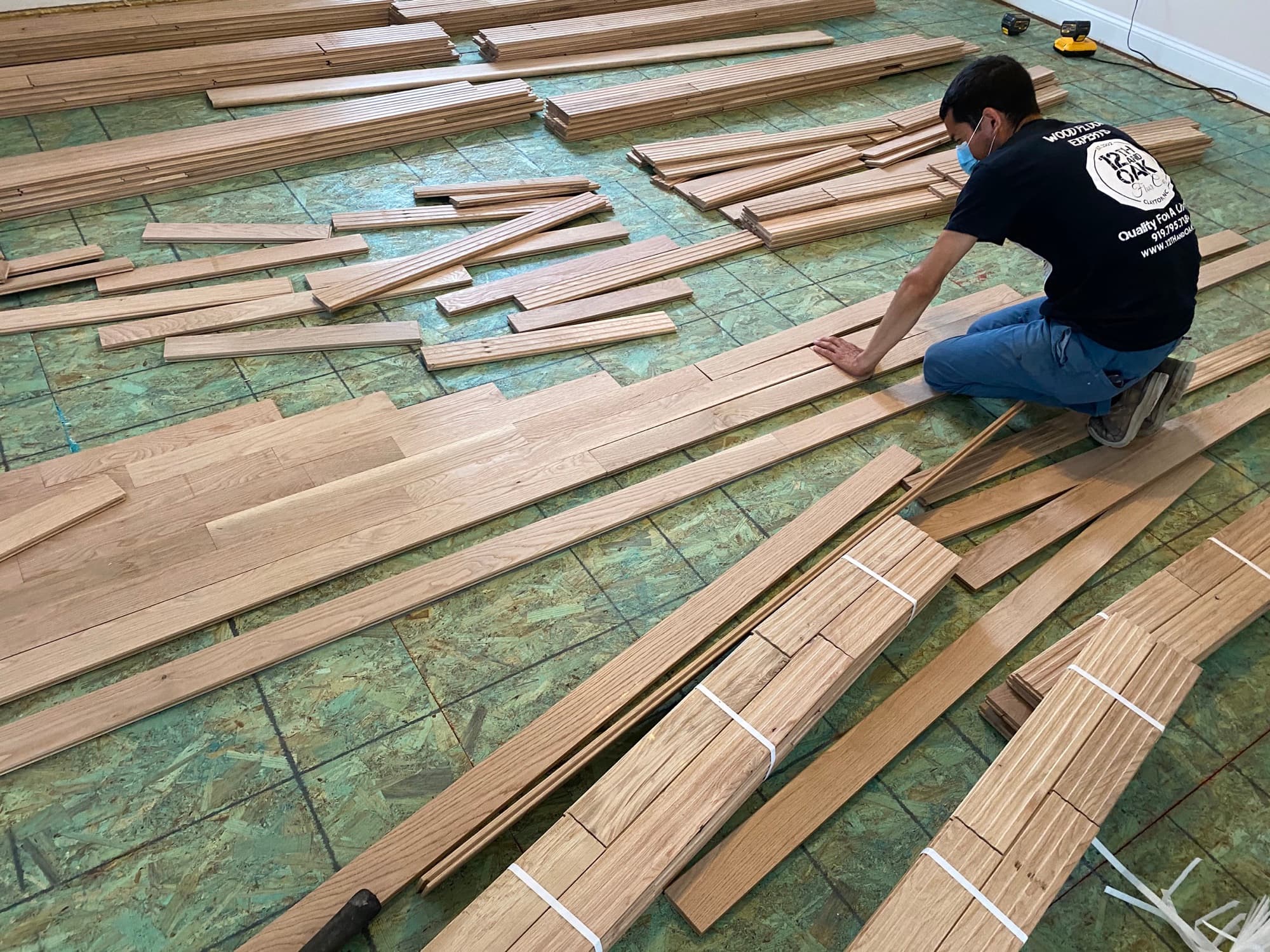 12th And Oak crew laying out wide plank white oak boards before installation Clayton NC