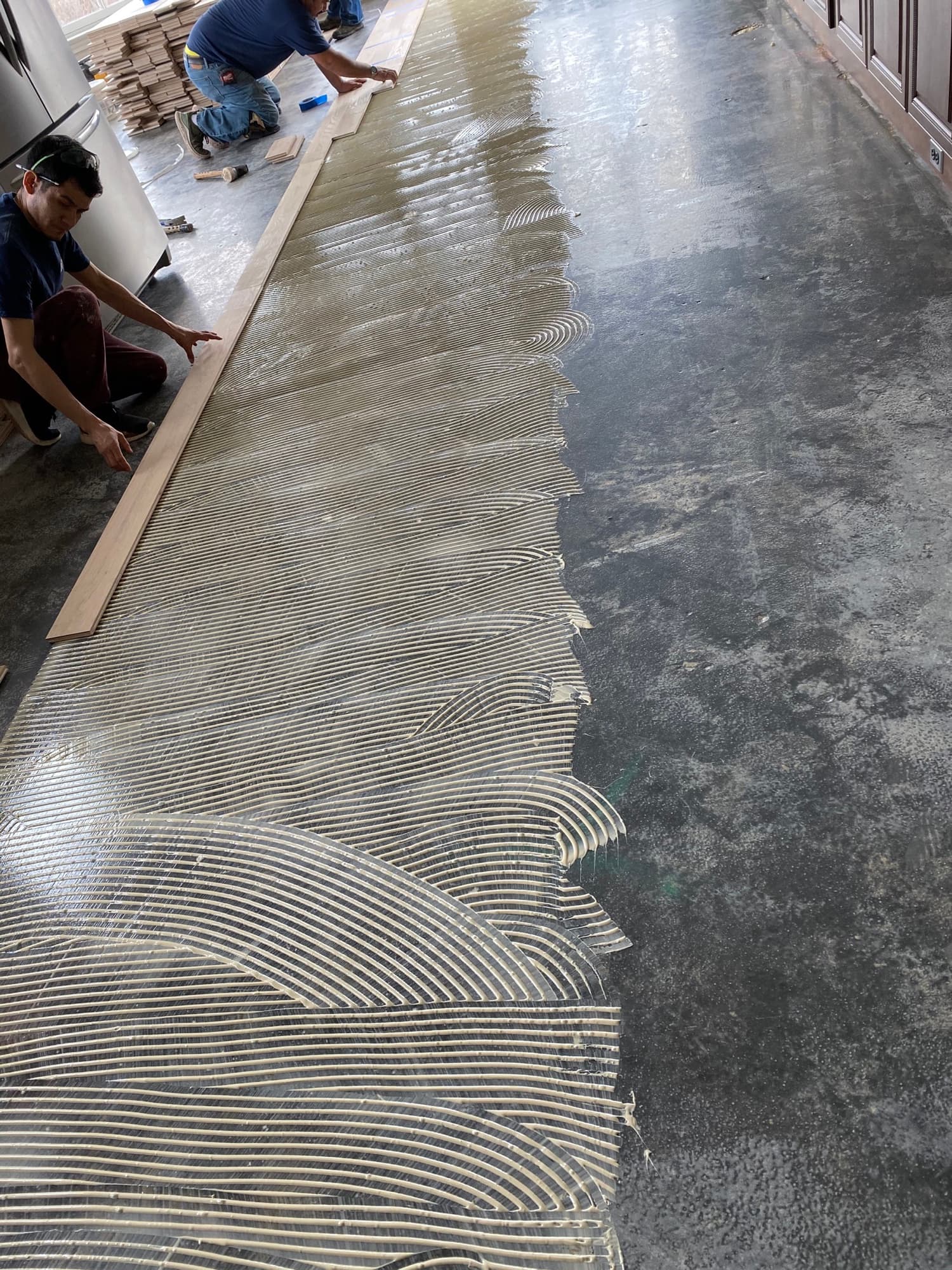Hardwood floor glue-down installation adhesive applied over concrete subfloor Clayton NC