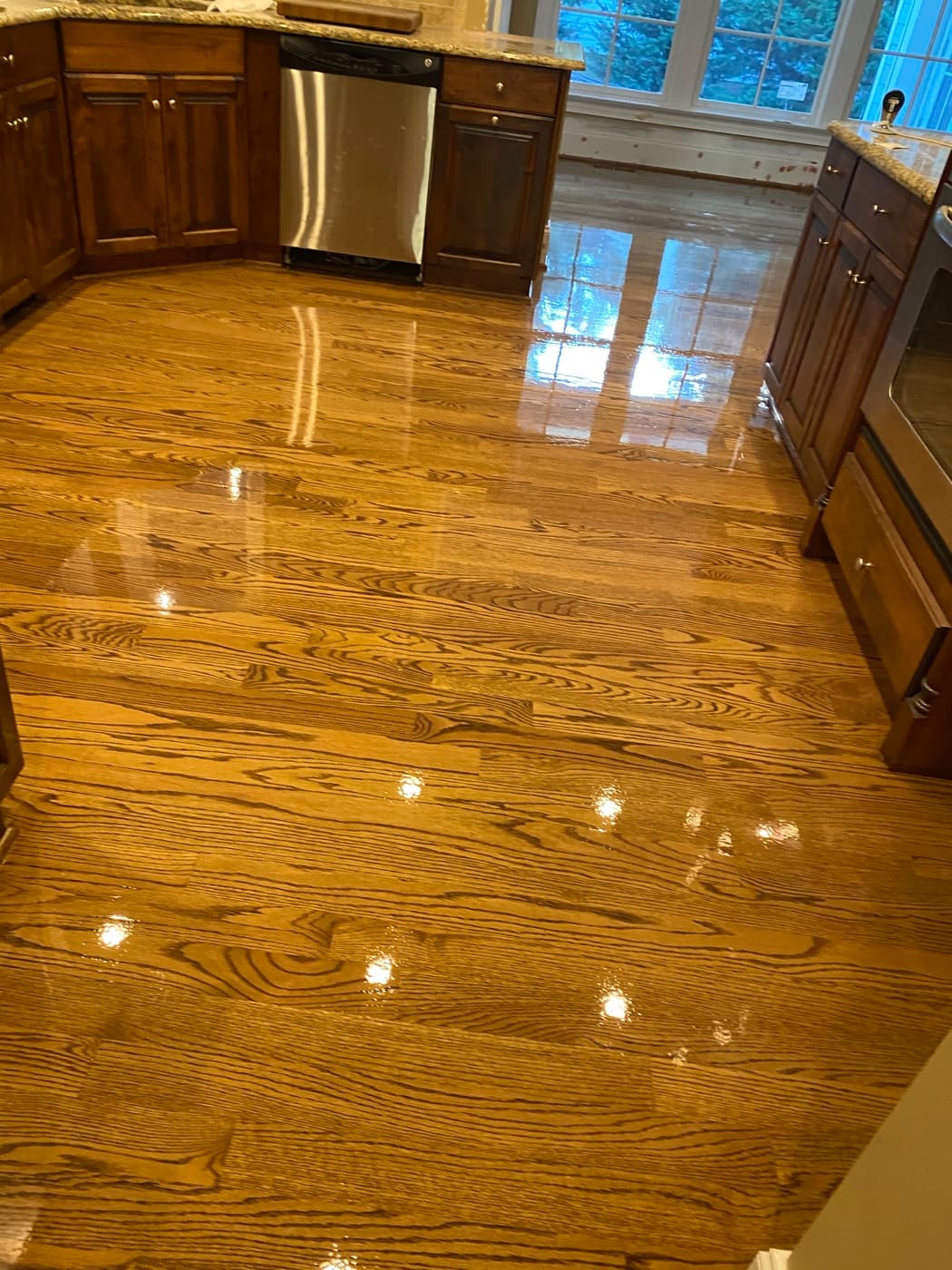 Red oak hardwood floors finished with DuraSeal Special Walnut stain and Bona Traffic HD in Crabtree Heights Raleigh NC under warm kitchen lighting