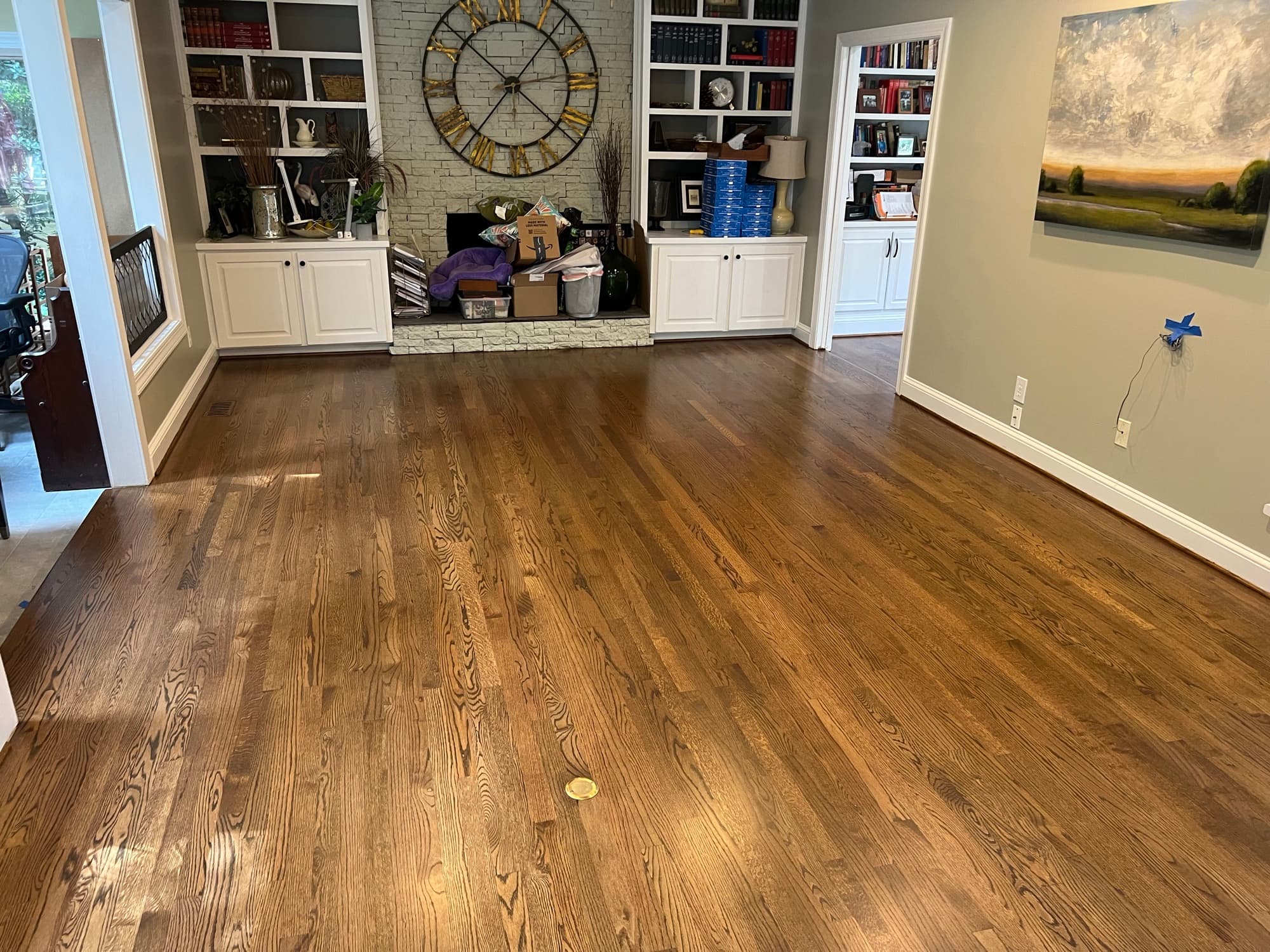Finished 3.25 inch red oak floors with custom blended stain and Bona Traffic HD in Lochmere Cary NC, living room with built-in bookshelves and stone fireplace