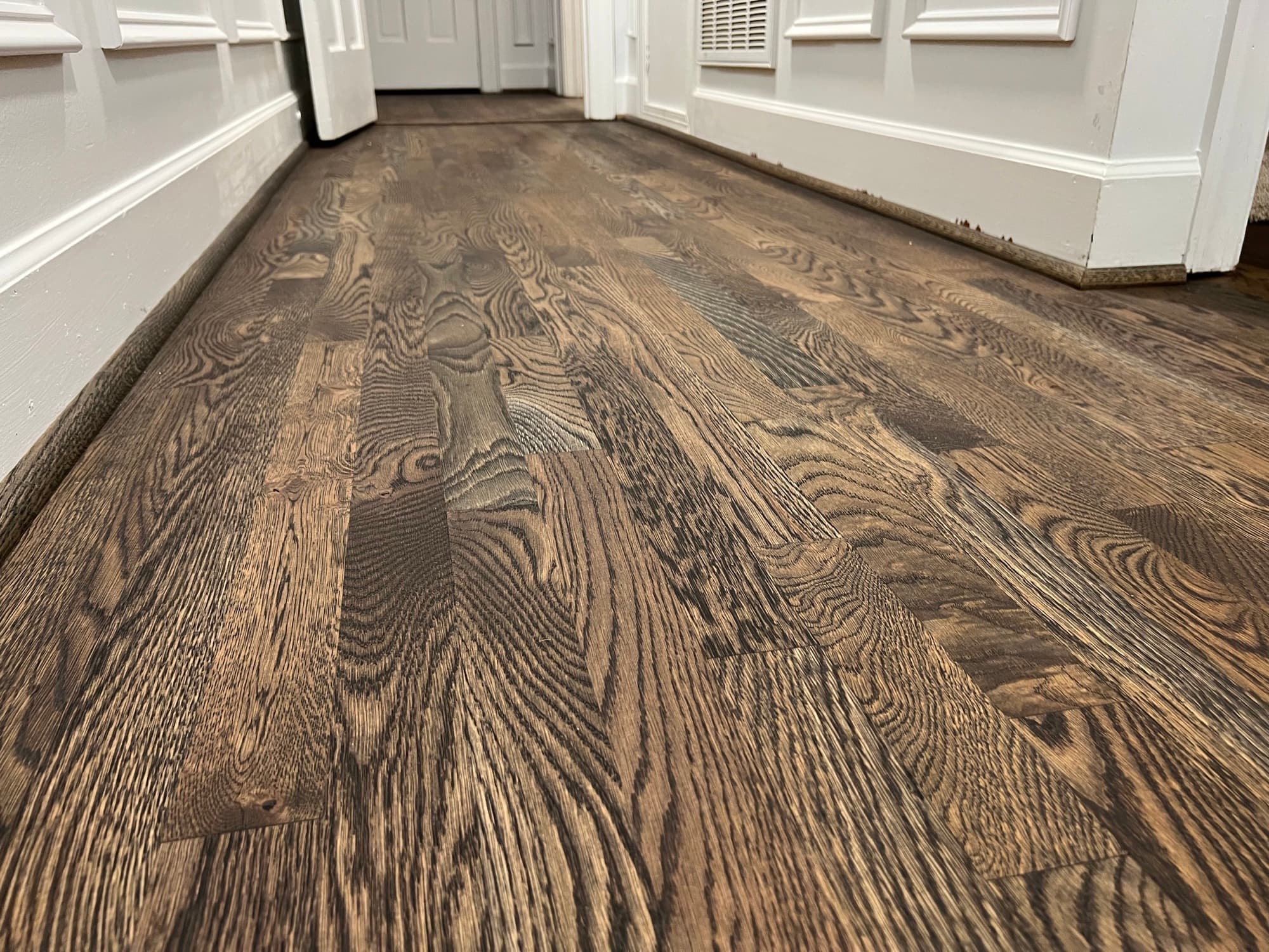 Dark stained white oak hardwood floors in hallway of Apex NC home by 12th And Oak Floor Co.